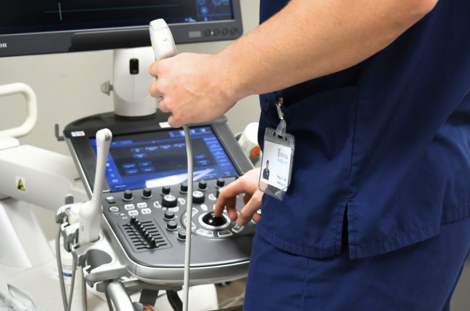 Clinician operating an ultrasound scanner during a private scan at Enigma Healthcare, Tarporley