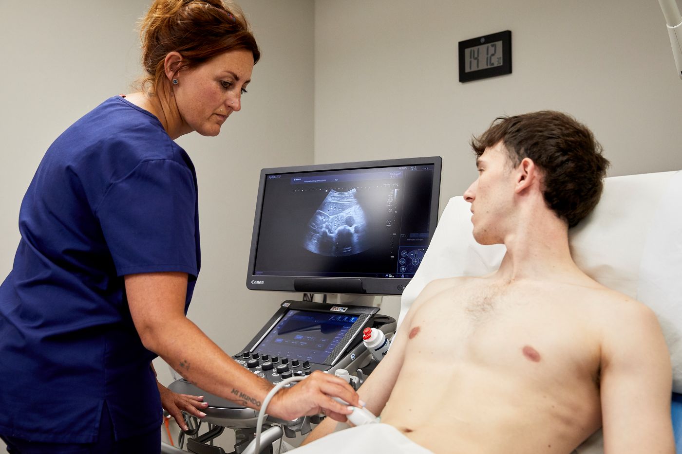 Clinician carrying out a lower abdominal ultrasound scan at Enigma Healthcare