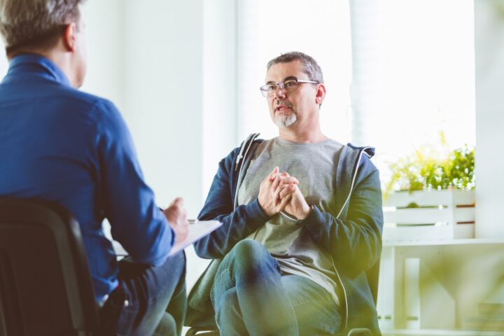 Man discussing his health with a healthcare professional during a consultation