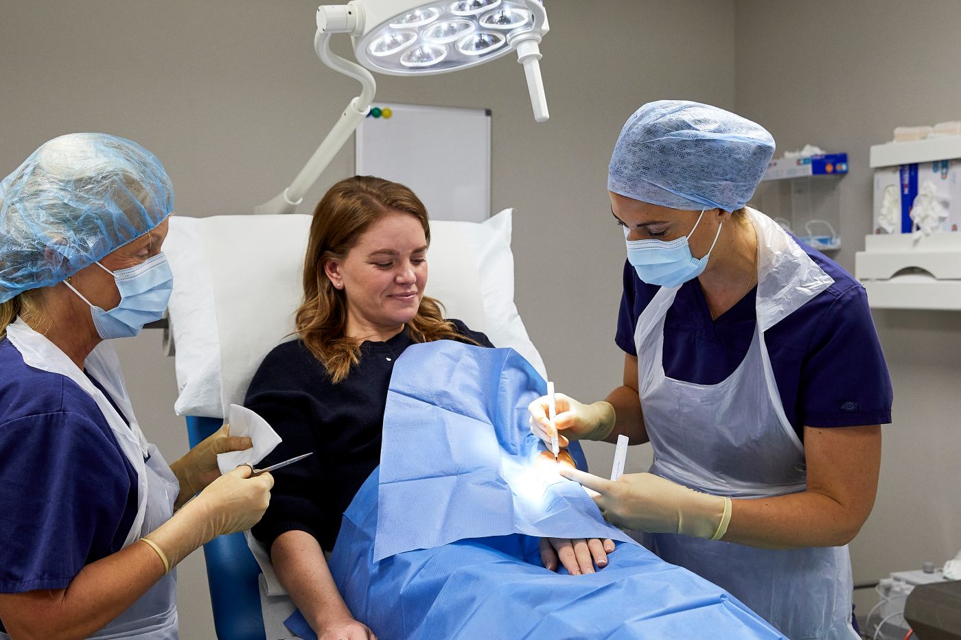 Dr Julia Brockley and a nurse carrying out a mole excision procedure at Enigma Healthcare